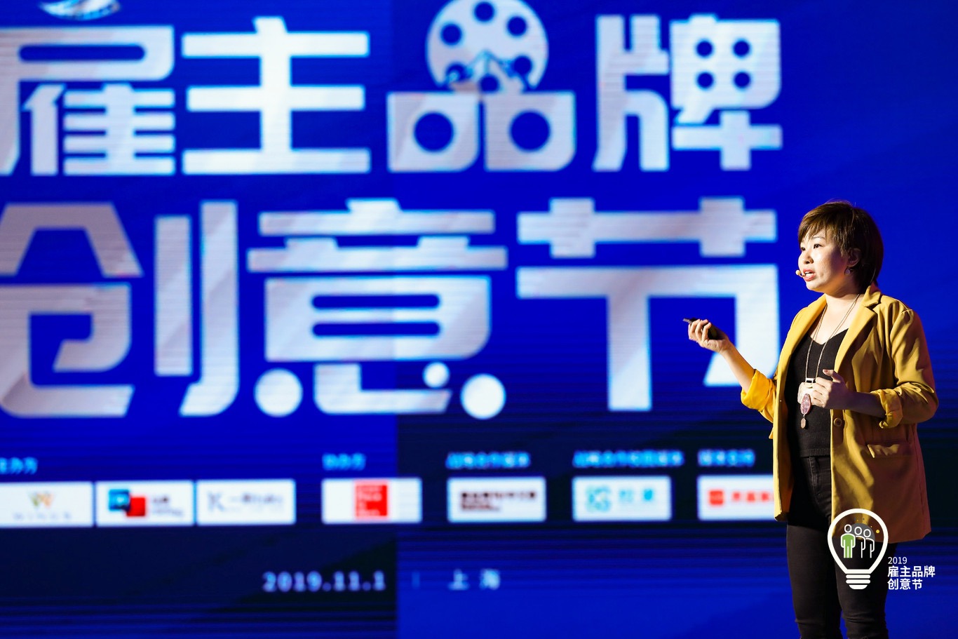 Glenn Tan presenting on stage, mid-gesture
